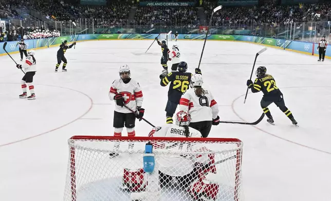 Sweden's players celebrate scoring the opening goal during a women's ice hockey bronze medal game between Switzerland and Sweden at the 2026 Winter Olympics, in Milan, Italy, Thursday, Feb. 19, 2026. (Alexander Nemenov/Pool Photo via AP)