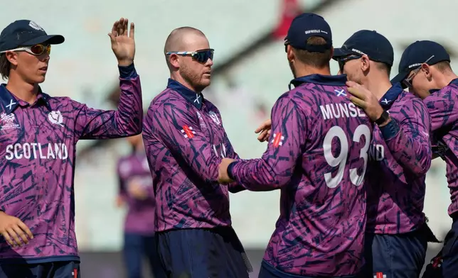 Scotland's Michael Leask, second left, celebrates the wicket of Italy's Harry Manenti with teammates during the T20 World Cup cricket match between Italy and Scotland in Kolkata, India, Monday, Feb. 9, 2026. (AP Photo/Bikas Das)
