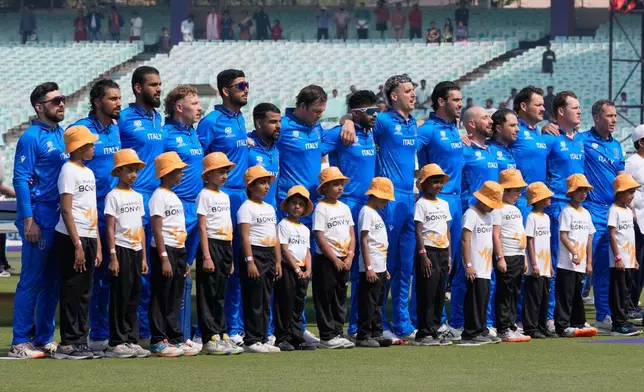 Italy players stand for the national anthems of the respective countries before the start of the T20 World Cup cricket match between them in Kolkata, India, Monday, Feb. 9, 2026. (AP Photo/Bikas Das)