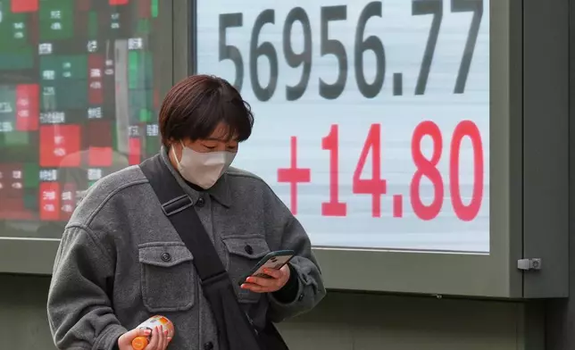 A person walks in front of an electronic stock board showing Japan's Nikkei index at a securities firm Monday, Feb. 16, 2026, in Tokyo. (AP Photo/Eugene Hoshiko)