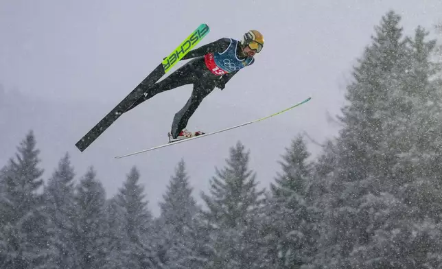 Johannes Rydzek, of Germany, soars through the air during the nordic combined team sprint at the 2026 Winter Olympics, in Predazzo, Italy, Thursday, Feb. 19, 2026. (AP Photo/Evgeniy Maloletka)