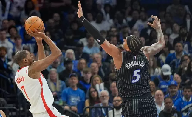 Houston Rockets forward Kevin Durant, left, shoots over Orlando Magic forward Paolo Banchero (5) during the first half of an NBA basketball game, Thursday, Feb. 26, 2026, in Orlando, Fla. (AP Photo/John Raoux)