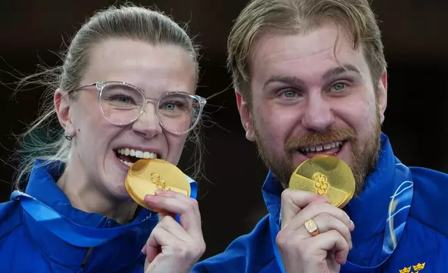 Sweden's Isabella Wranaa and Rasmus Wranaa celebrate on the podium after winning the gold medal match of the mixed doubles curling at the 2026 Winter Olympics, in Cortina d'Ampezzo, Italy, Tuesday, Feb. 10, 2026. (AP Photo/Misper Apawu)