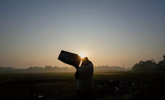 A migratory beekeeper carries a bee box to place near a mustard field in the Bodomukh village in Baksa district of Assam, India, Monday, Jan. 12, 2026. (AP Photo/Anupam Nath)