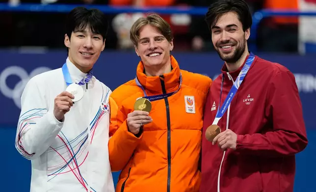 From left to right, silver medalist Hwang Daeheon of South Korea, gold medalist Jens van 't Wout of the Netherlands and bronze medalist Roberts Kruzbergs of Latvia receive their medals after the short track speed skating men's 1500m at the 2026 Winter Olympics, in Milan, Italy, Saturday, Feb. 14, 2026. (AP Photo/Ashley Landis)