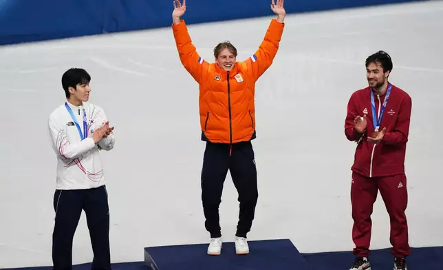 Gold medalist Jens van 't Wout of the Netherlands jumps on the podium to receive his medal after the short track speed skating men's 1500m at the 2026 Winter Olympics, in Milan, Italy, Saturday, Feb. 14, 2026. (AP Photo/Francisco Seco)