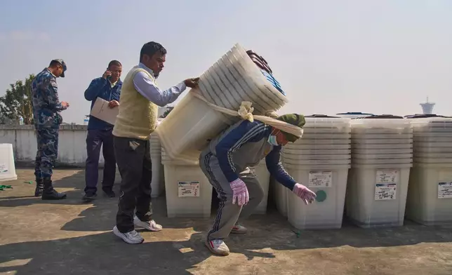 A laborer carries ballot boxes to a vehicle for distribution across the country ahead of the general election in Kathmandu, Nepal, Feb. 8, 2026. (AP Photo/Niranjan Shrestha)