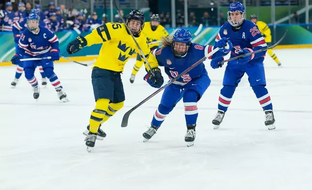 United States' Haley Winn, right, challenges for the puck with Sweden's Lisa Johansson during a semifinal match of women's ice hockey between the United States and Sweden at the 2026 Winter Olympics, in Milan, Italy, Monday, Feb. 16, 2026. (AP Photo/Petr David Josek)