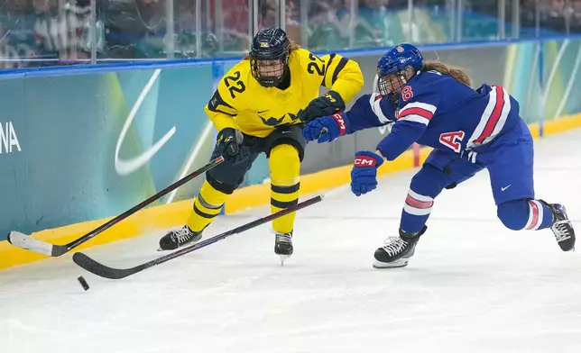 Sweden's Hanna Thuvik (22) is challenged by United States' Haley Winn (8) during a women's ice hockey semifinal game between the United States and Sweden at the 2026 Winter Olympics, in Milan, Italy, Monday, Feb. 16, 2026. (AP Photo/Hassan Ammar)