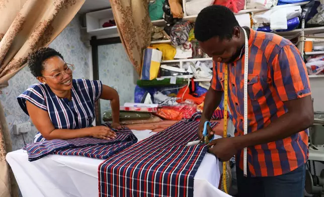 Perfectual Linnan, a fashion designer, interacts with a staff member at her workshop in Accra, Ghana, Wednesday, Feb. 18, 2026. (AP Photo/Tsraha Yaw)