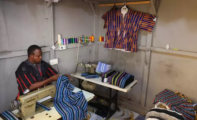 Moses Adibasa, a traditional fugu garment maker, works on in his workshop in Accra, Ghana, Wednesday, Feb. 18, 2026. (AP Photo/Tsraha Yaw)