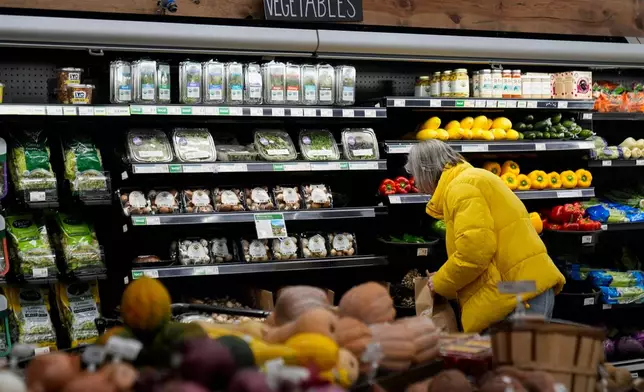 A shopper looks at produce at a grocery store Tuesday, Feb. 10, 2026, in Chicago. (AP Photo/Erin Hooley)