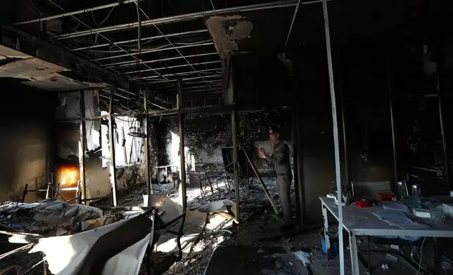 A Thai policeman inspects a damaged work station at a scam compound in O'Smach, Cambodia, Monday, Feb. 2, 2026, (AP Photo/Sakchai Lalit)