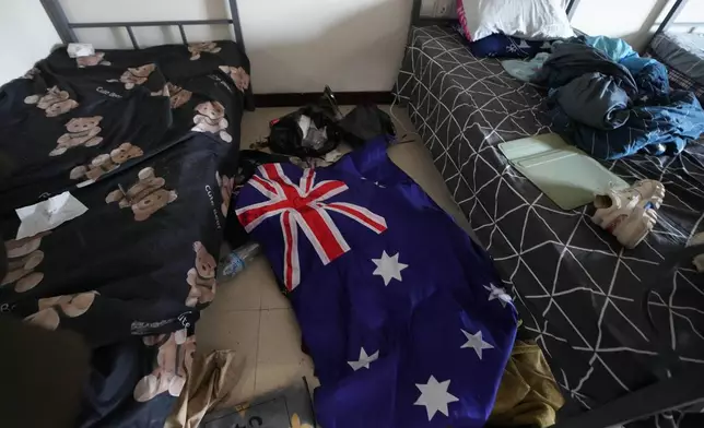 An Australian flag lies on the floor of an abandoned bedroom at a scam center in O'Smach, Cambodia, Monday, Feb. 2, 2026. (AP Photo/Sakchai Lalit)