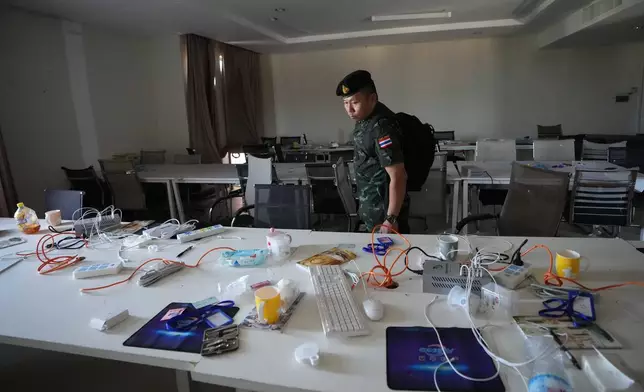 A Thai solider inspects a work station inside a scam center in O'Smach, Cambodia, Monday, Feb. 2, 2026, (AP Photo/Sakchai Lalit)