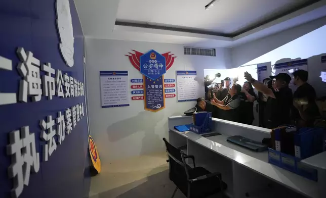 Thai media inspect what appears to be a mock-up set resembling a Chinese police station at a scam center in O'Smach, Cambodia, Monday, Feb. 2, 2026. (AP Photo/Sakchai Lalit)