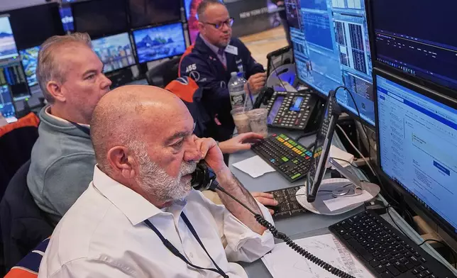 Trader Joseph Stevens, foreground, works with colleagues on the floor of the New York Stock Exchange, Tuesday, Feb. 3, 2026. (AP Photo/Richard Drew)