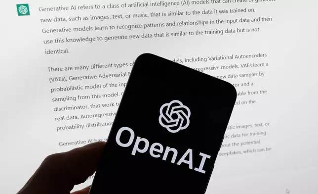 FILE - The OpenAI logo is displayed on a mobile phone in front of a computer screen with output from ChatGPT, March 21, 2023, in Boston. (AP Photo/Michael Dwyer, File)