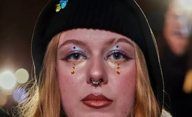 A woman attends a demonstration marking the fourth anniversary of the Russian invasion of Ukraine, in Warsaw, Poland, Tuesday, Feb. 24, 2026. (AP Photo/Beata Zawrzel)