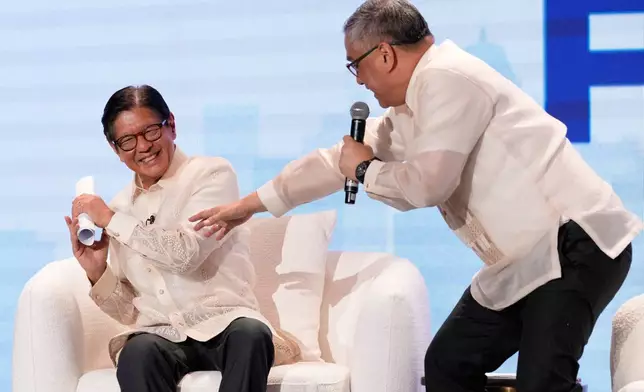 Philippine President Ferdinand Marcos Jr. left, gestures beside broadcast journalist Rico Hizon at the ASEAN Editors and Economic Opinon Leaders Forum in Makati, Philippines, Tuesday, Feb. 24, 2026. (AP Photo/Aaron Favila)