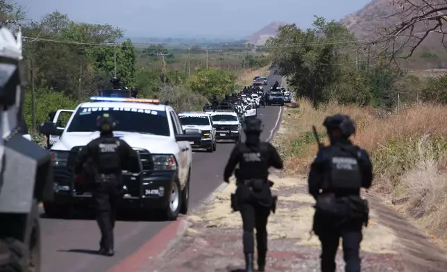 National Guards patrol a highway near Aguililla, Mexico, Tuesday, Feb. 24, 2026, after the Mexican army killed Jalisco New Generation Cartel leader Nemesio Oseguera Cervantes, known as "El Mencho." (AP Photo/Armando Solis)