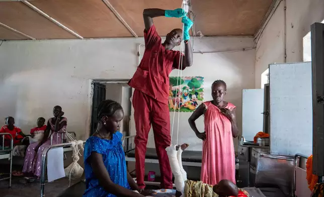 Nyayual Chuol, right, watches her 18-month-old grandson Kool Gatyen Pajock, who was shot during the conflict-hit state, receive treatment at the Akobo County Hospital in South Sudan, Saturday, Feb. 21, 2026. (AP Photo/Florence Miettaux)