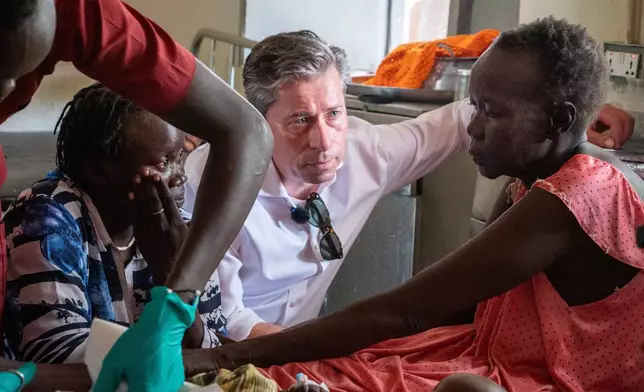 Tom Fletcher, the U.N. under-secretary-general for humanitarian affairs and head of OCHA, center, talks with patients at Akobo County Hospital in South Sudan, Saturday, Feb. 21, 2026. (AP Photo/Florence Miettaux)
