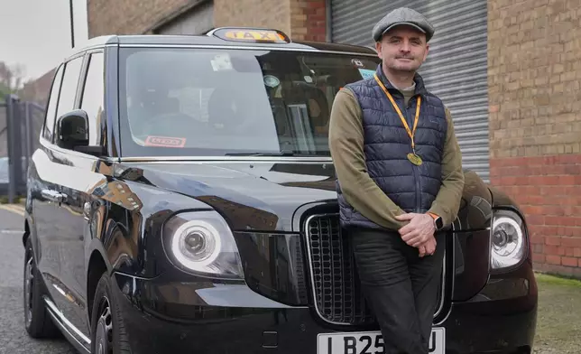 Britain Robotaxis Frank O'Beirne, black cab driver poses with his taxi in London, Monday, Feb. 9, 2026. (AP Photo/Kin Cheung)
