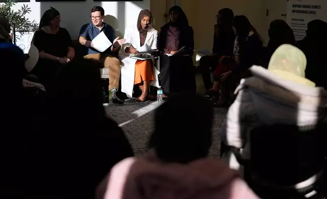 Dr. Bryan Fate, second left, and family nurse practitioner and CEO of Inspire Change Clinic Munira Maalimisaq, middle, lead a community discussion on vaccine education at Inspire Change Clinic, Nov. 22, 2025, in Minneapolis. (AP Photo/Abbie Parr)