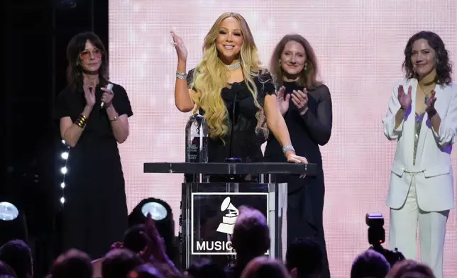 Mariah Carey, center, accepts the 2026 MusiCares Persons of the Year award during MusiCares Person of the Year honoring Mariah Carey on Friday, Jan. 30, 2026, in Los Angeles. (AP Photo/Chris Pizzello)