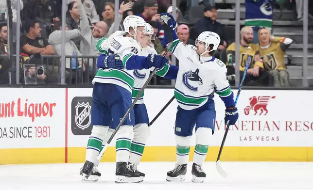 Vancouver Canucks defenseman Elias Pettersson (25), left wing Liam Ohgren (92), and right wing Conor Garland (8) celebrate after Pettersson's goal against the Vegas Golden Knights during the second period of an NHL hockey game Wednesday, Feb. 4, 2026, in Las Vegas. (AP Photo/Ian Maule)