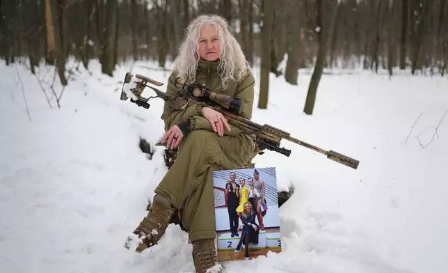 Tetiana Khimion 47, now a sniper in the Ukrainian army, poses with a photograph of herself as a dance teacher taken before Russia's full-scale invasion, in a park in Kyiv, Ukraine, Sunday, Feb. 22, 2026. (AP Photo/Sergei Grits)