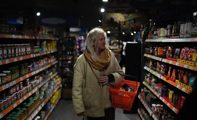 Tetiana Khimion, 47, a dance teacher before Russia's full-scale invasion, now a sniper in the Ukrainian army, shops for groceries in Kyiv, Ukraine, Sunday, Feb. 22, 2026. (AP Photo/Sergei Grits)
