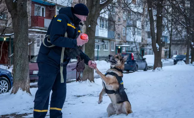 Ivan Khmelnytski, 25, a rescue worker, plays with his dog after work in Bila Tserkva, Ukraine, Saturday, Feb. 21, 2026. (AP Photo/Dan Bashakov)