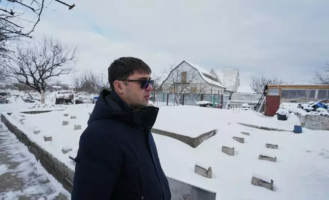 Yaroslav Nehoda, 40, stands next to the site where his wife, daughter and niece were killed in a drone strike, in the Kyiv region of Ukraine, Thursday, Feb. 19, 2026. (AP Photo/Sergei Grits)