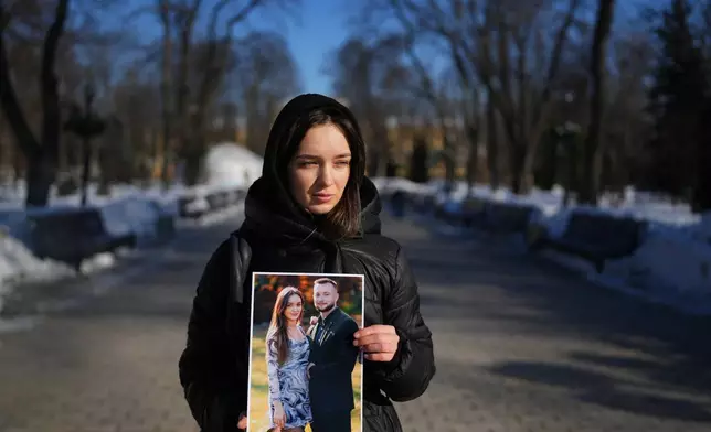 Liliia, 30, holds a photograph of her with her boyfriend Bohdan, now a prisoner of war, as she poses for a portrait in Kyiv, Ukraine, Saturday, Feb. 21, 2026. (AP Photo/Sergei Grits)