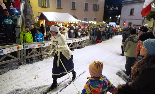 Spectators watch as Bormio residents compete in an annual cross-country ski race through the streets of the old town, this year coinciding with the 2026 Winter Olympics, in Bormio, Italy, Friday, Feb. 13, 2026. (AP Photo/Rebecca Blackwell)