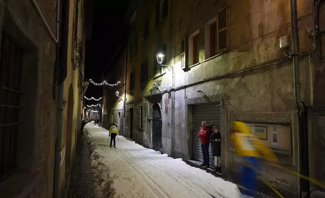 Spectators watch as Bormio residents compete in an annual cross-country ski race through the streets of the old town, this year coinciding with the 2026 Winter Olympics, in Bormio, Italy, Friday, Feb. 13, 2026. (AP Photo/Rebecca Blackwell)