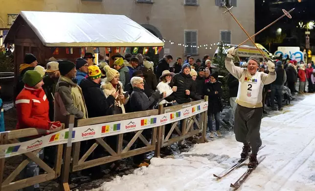 Spectators watch as Bormio residents participate in an annual cross-country ski race through the streets of the old town, this year coinciding with the 2026 Winter Olympics, in Bormio, Italy, Friday, Feb. 13, 2026. (AP Photo/Rebecca Blackwell)