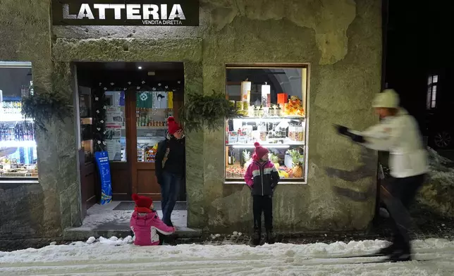 Spectators watch as Bormio residents compete in an annual cross-country ski race through the streets of the old town, this year coinciding with the 2026 Winter Olympics, in Bormio, Italy, Friday, Feb. 13, 2026. (AP Photo/Rebecca Blackwell)