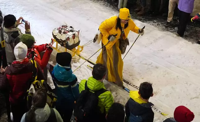A participant tows a decorated sled as Bormio residents compete in an annual cross-country ski race through the streets of the old town, this year coinciding with the 2026 Winter Olympics, in Bormio, Italy, Friday, Feb. 13, 2026. (AP Photo/Rebecca Blackwell)