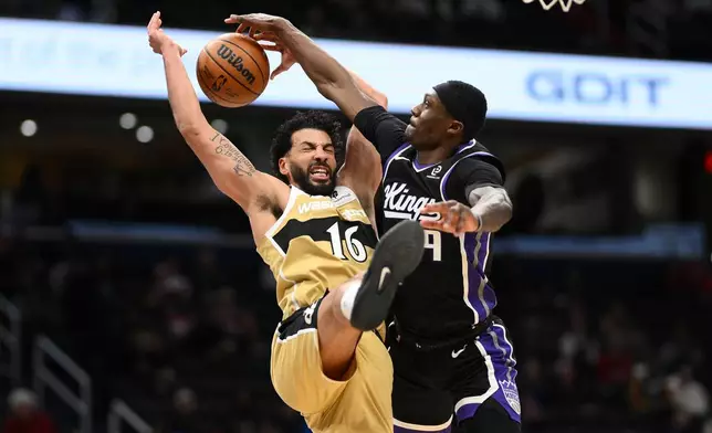Sacramento Kings guard Daeqwon Plowden, right, blocks Washington Wizards forward Anthony Gill (16) during the first half of an NBA basketball game, Sunday, Feb. 1, 2026, in Washington. (AP Photo/Nick Wass)