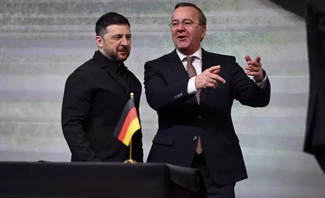 Ukrainian President Volodymyr Zelenskyy, left, and German Defence Minister Boris Pistorius talk during their visit of drone producing company Quantum Frontline Industries near Munich, Germany, Friday, Feb. 13, 2026. (Sven Hoppe/dpa via AP)