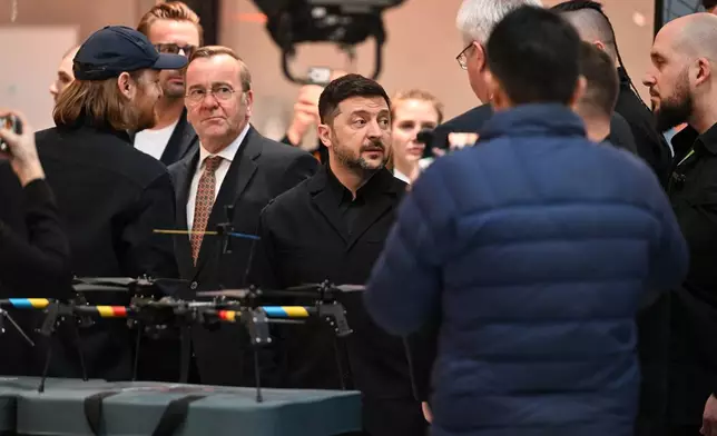 Ukrainian President Volodymyr Zelenskyy, centre, German Defence Minister Boris Pistorius, centre left, attend their visit of drone producing company Quantum Frontline Industries near Munich, Germany, Friday, Feb. 13, 2026. (Sven Hoppe/dpa via AP)