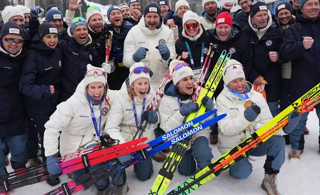 Haakon, Crown Prince of Norway, center, poses with Heidi Weng, Karoline Simpson-Larsen, Astrid Oeyre Slind, and Kristin Austgulen Fosnaes, of Norway, and their team after they won the gold medal in the cross country skiing women's 4 x 7.5km relay at the 2026 Winter Olympics, in Tesero, Italy, Saturday, Feb. 14, 2026. (AP Photo/Matthias Schrader)