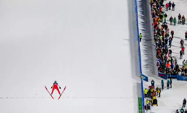 Johann Andre Forfang, of Norway, soars through the air during his trial jump of the ski jumping men's super team competition at the 2026 Winter Olympics, in Predazzo, Italy, Monday, Feb. 16, 2026. (AP Photo/Matthias Schrader)