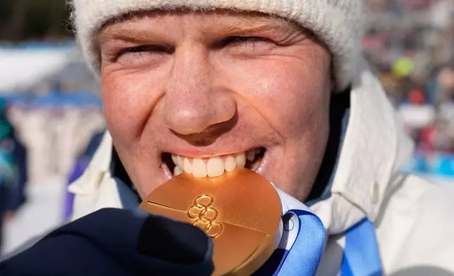 Johannes Dale-Skjevdal, of Norway, poses with the gold medal for the men's 15-kilometer mass start biathlon race at the 2026 Winter Olympics in Anterselva, Italy, Friday, Feb. 20, 2026. (AP Photo/Mosa'ab Elshamy)