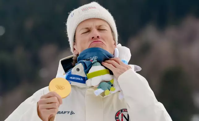 Gold medalist Johannes Hoesflot Klaebo, of Norway, poses on the podium of the cross-country skiing men's sprint classic at the 2026 Winter Olympics, in Tesero, Italy, Tuesday, Feb. 10, 2026. (AP Photo/Evgeniy Maloletka)