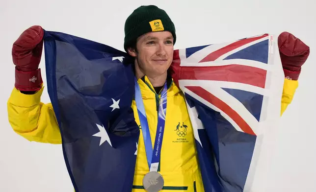 Silver medalist Australia's Scotty James holds an Australian flag after the men's snowboarding halfpipe finals at the 2026 Winter Olympics, in Livigno, Italy, Friday, Feb. 13, 2026. (AP Photo/Gregory Bull)