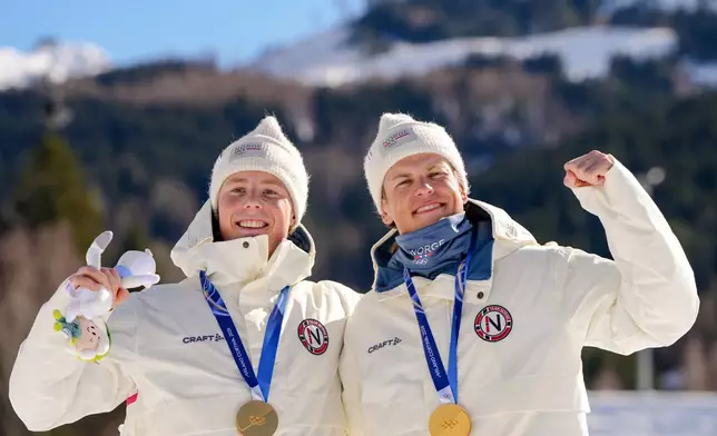 Johannes Hoesflot Klaebo and Einar Hedegart, of Norway, pose after winning the gold medal in cross-country skiing men's team sprint free at the 2026 Winter Olympics, in Tesero, Italy, Wednesday, Feb. 18, 2026. (AP Photo/Kirsty Wigglesworth)